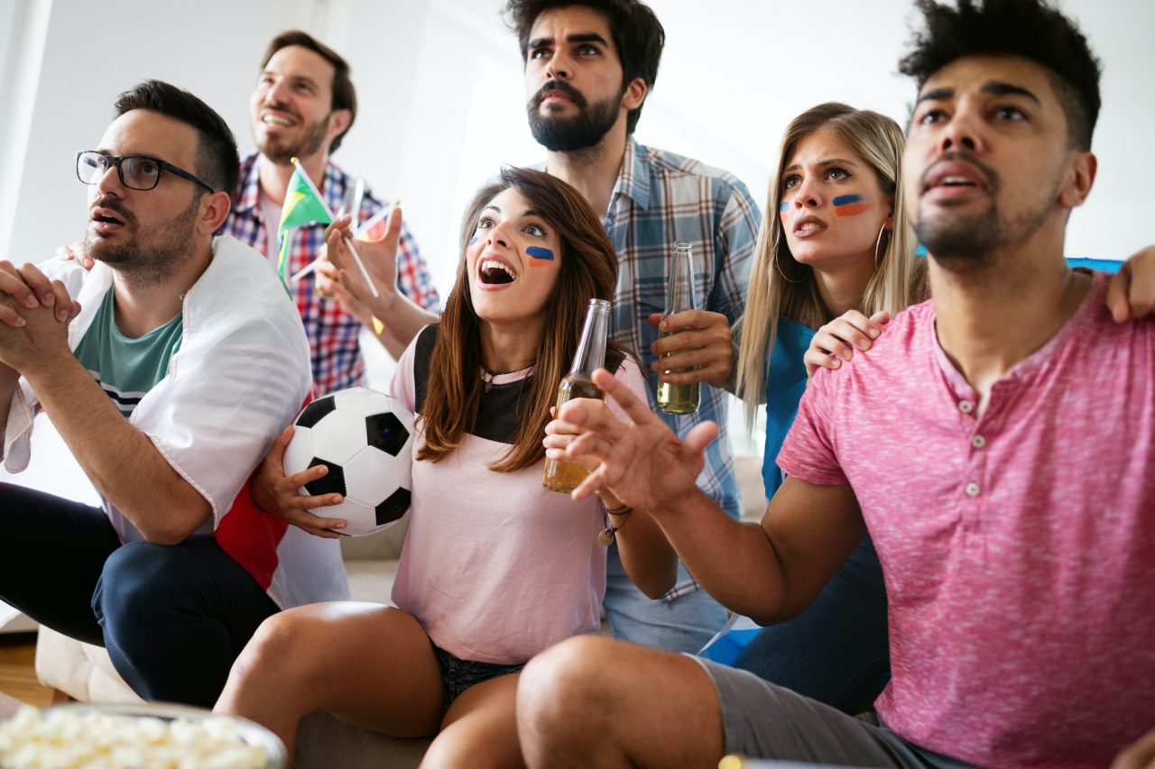 Friends celebrating a goal while watching live football on HawkTV
